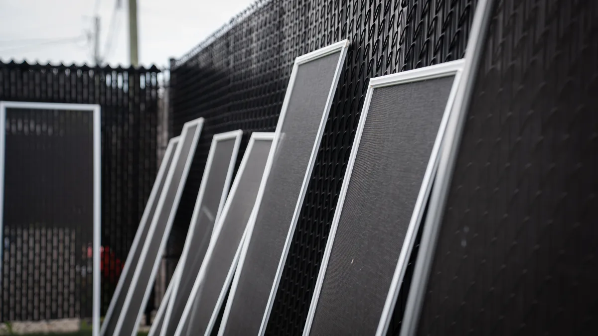 Window screens lined against a fence